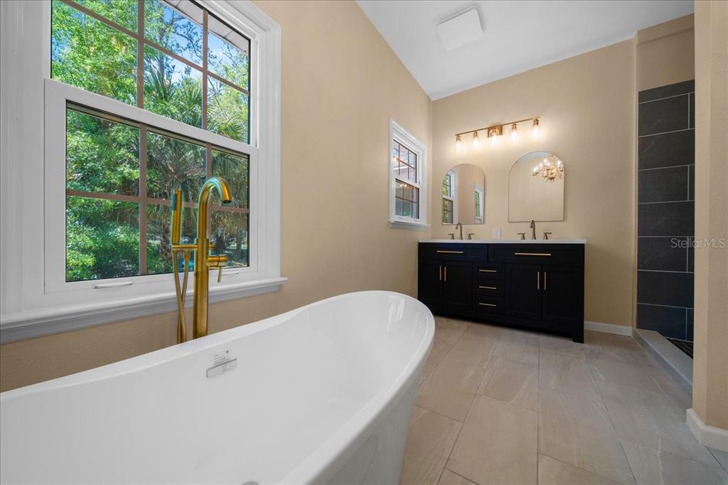 7808 Northeast 75th Street Gainesville, FL 32609 - Photo 36 of 78 a spacious bathroom with a tub sink and mirror