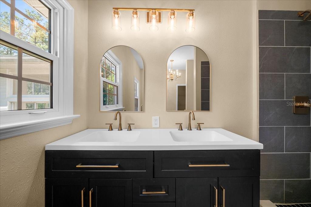 7808 Northeast 75th Street Gainesville, FL 32609 - Photo 39 of 78 a bathroom with a double vanity sink and a mirror