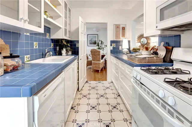 a large kitchen with stainless steel appliances granite countertop a stove and a dining table chair