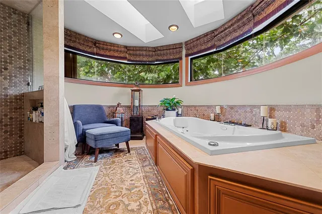 a spacious bathroom with a tub and window