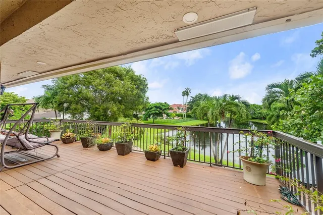 a balcony with wooden floor and outdoor seating