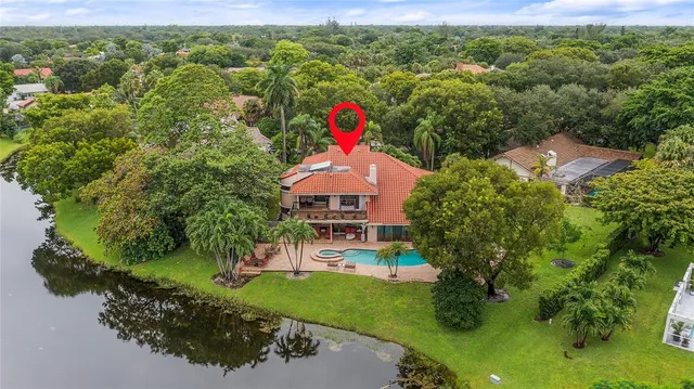 an aerial view of residential houses with outdoor space and trees