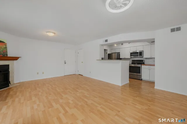 a view of a kitchen with wooden floor and electronic appliances
