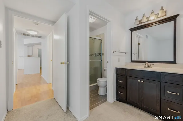 a spacious bathroom with a toilet sink and mirror