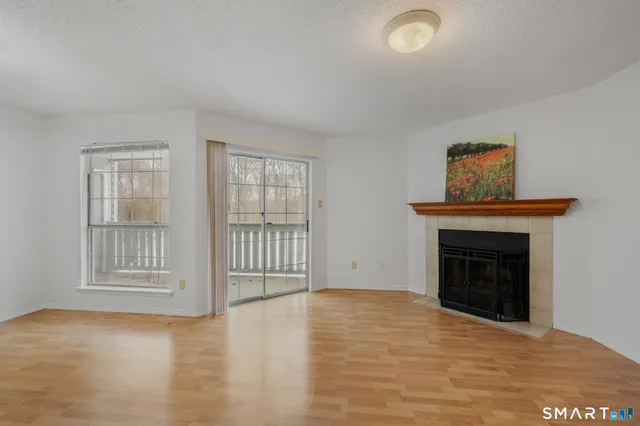wooden floor fireplace and windows in an empty room