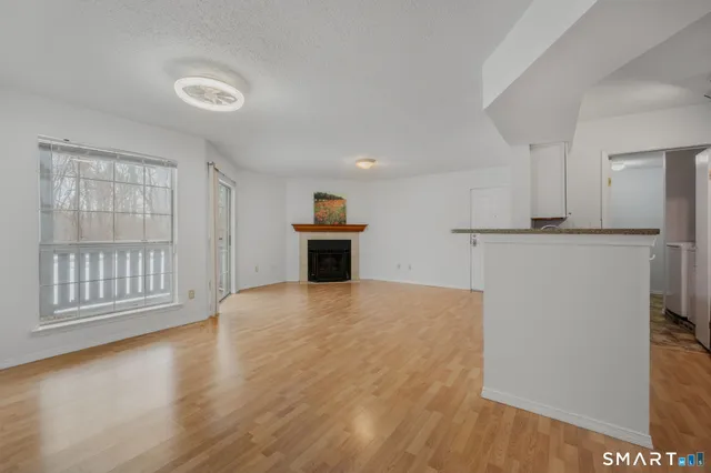 a view of empty room with wooden floor and window