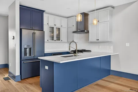 a kitchen with kitchen island granite countertop a sink cabinets and stainless steel appliances
