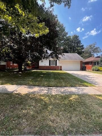 1192 Blanchester Road Cleveland, OH 44124 - Photo 1 of 2 View of front of home with brick siding, concrete driveway, a garage, and a front lawn