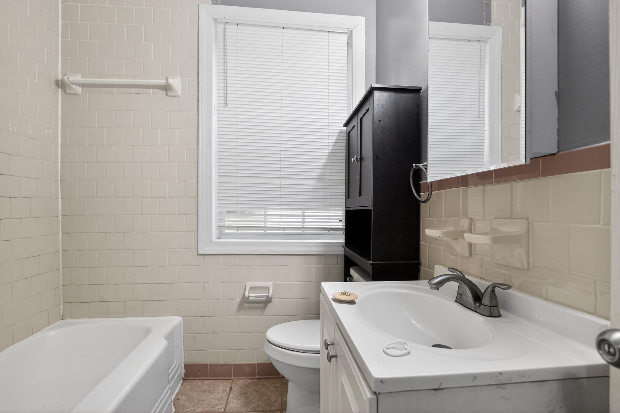 4199 Auburn Road Memphis, TN 38116 - Photo 25 of 32 Bathroom featuring a white bathtub, ceramic tile walls, and a window with blinds