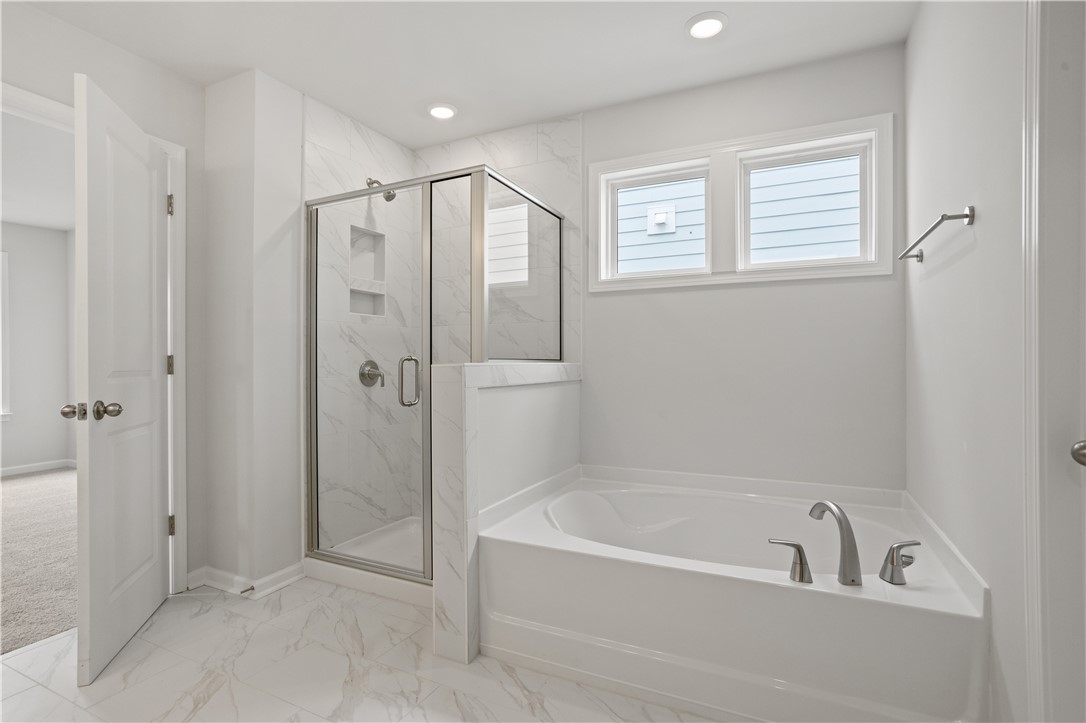 555 Hydrangea Street, Unit LOT 47 Seneca, SC 29678 - Photo 25 of 38 Luxurious soaking tub and a spacious glass-enclosed shower create a serene bathing experience.