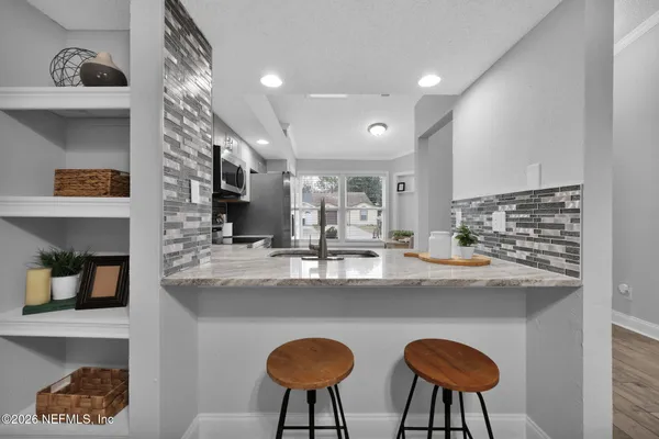 a kitchen with stainless steel appliances granite countertop a sink and a refrigerator