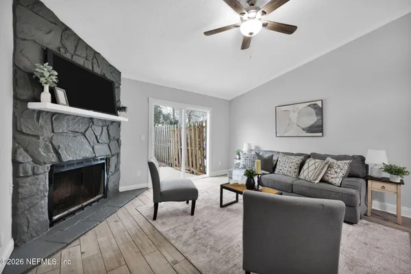 a living room with furniture a flat screen tv and a fireplace