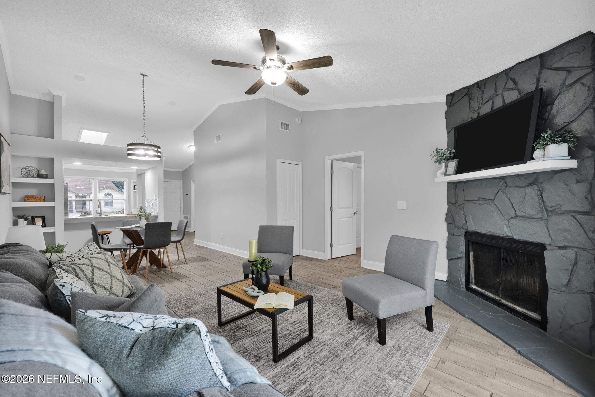 2494 Spring Vale Road Jacksonville, FL 32246 - Photo 17 of 36 a living room with furniture a flat screen tv and a fireplace