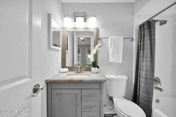 a bathroom with a granite countertop toilet sink and mirror
