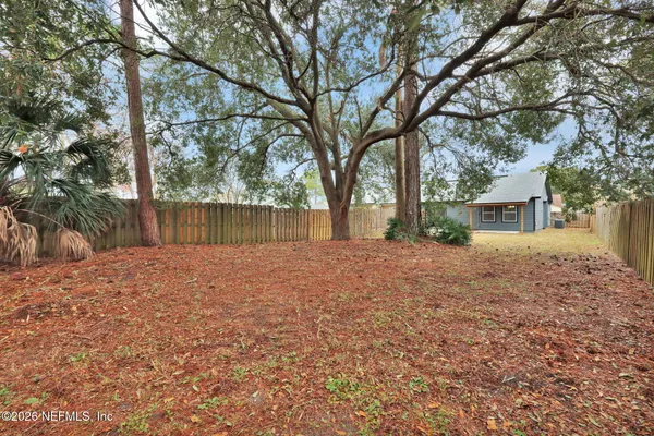 a backyard of a house with a large tree