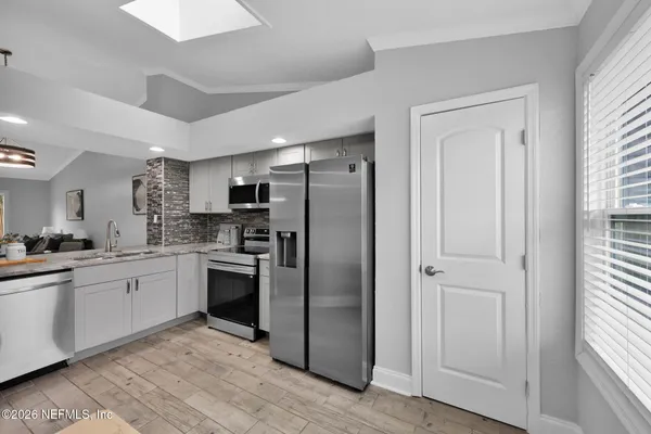 a kitchen with stainless steel appliances granite countertop a refrigerator and a stove top oven