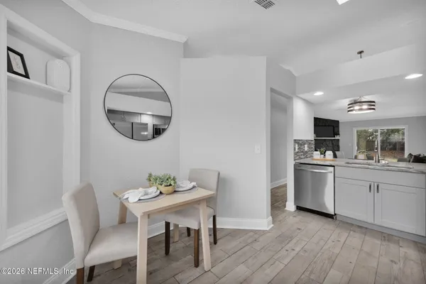 a kitchen with a dining table chairs and refrigerator