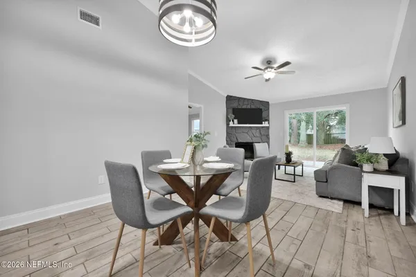 a view of a dining room with furniture a fireplace and wooden floor