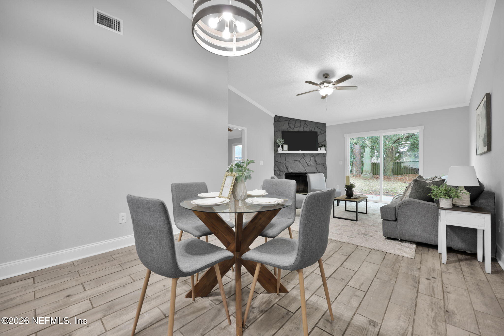 2494 Spring Vale Road Jacksonville, FL 32246 - Photo 10 of 36 a view of a dining room with furniture a fireplace and wooden floor