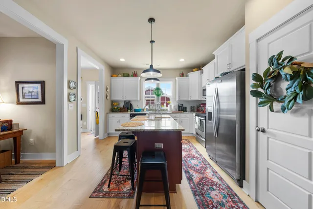 a kitchen with stainless steel appliances granite countertop a sink a counter cabinets and a window
