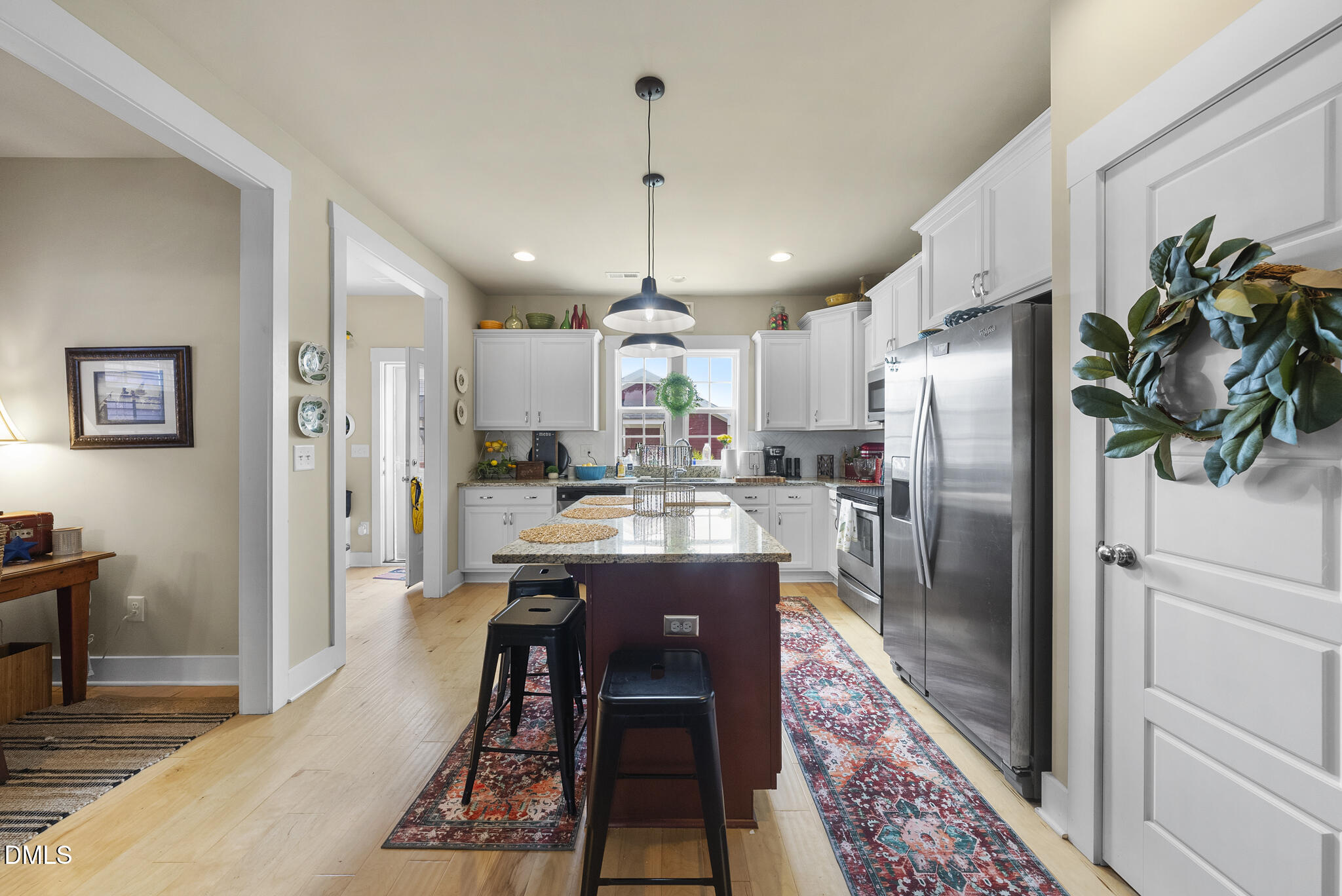 1985 Big Falls Drive Wendell, NC 27591 - Photo 3 of 24 a kitchen with stainless steel appliances granite countertop a refrigerator a sink dishwasher a stove and a dining table with wooden floor