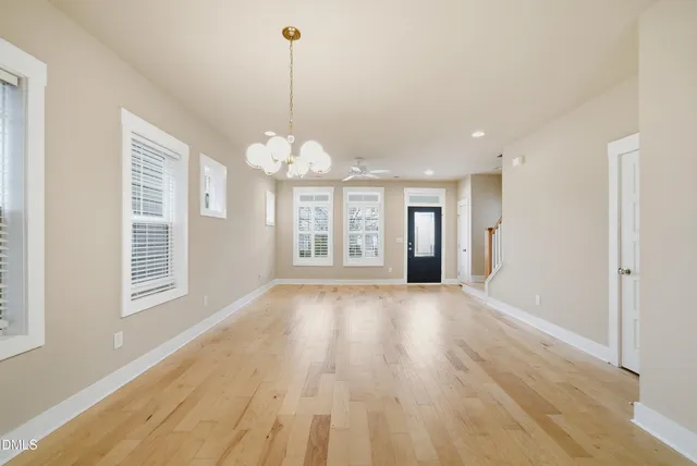 a view of a big room with wooden floor windows and a chandelier