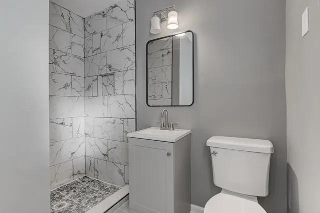 a bathroom with a toilet sink and mirror