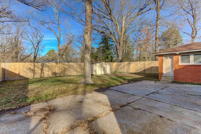 a view of backyard with wooden fence