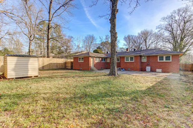 a front view of house with yard and trees around