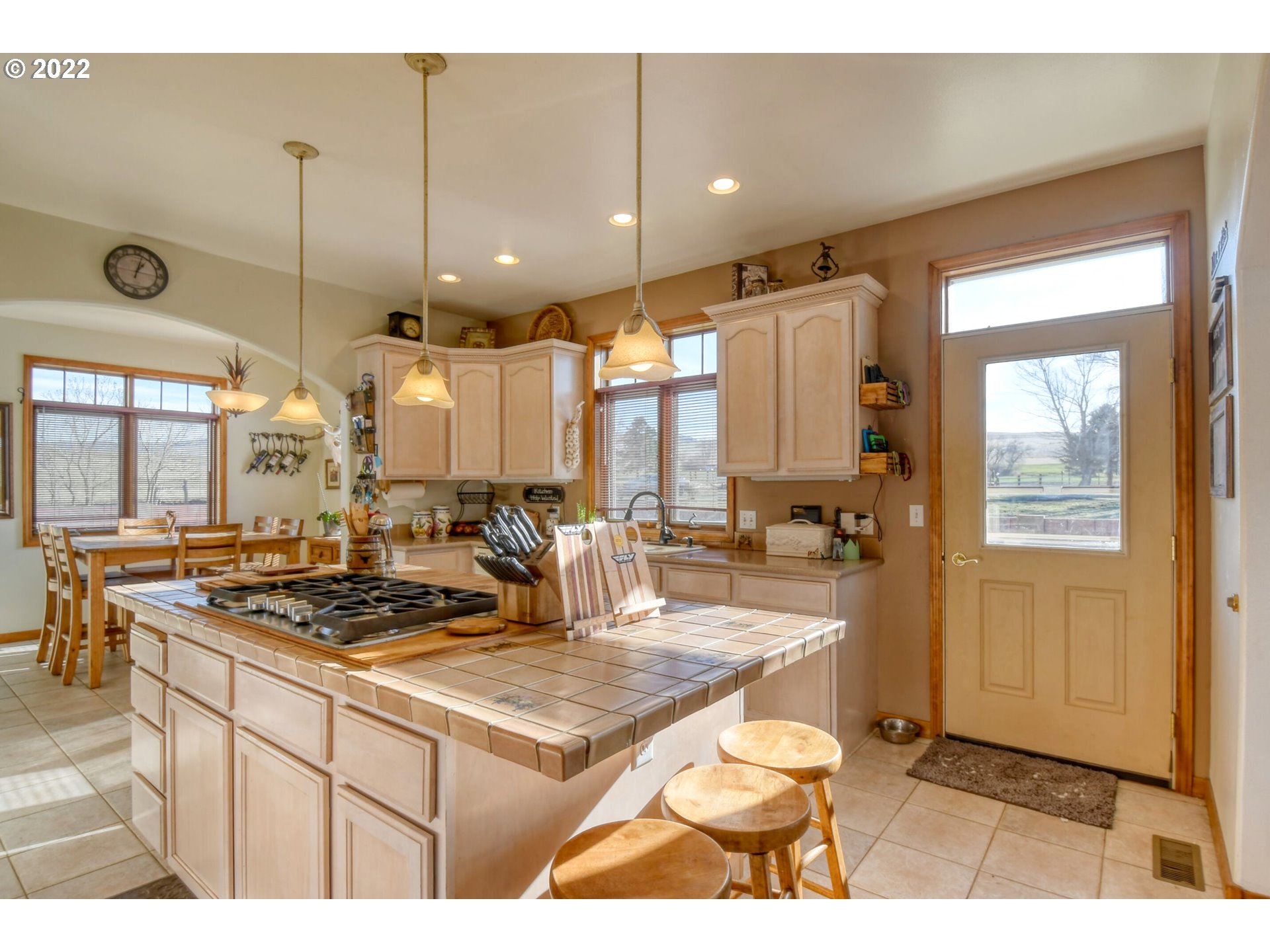 48903 Cayuse Road Pendleton, OR 97801 - Photo 19 of 32 a kitchen with a stove a refrigerator a sink a dining table and chairs with wooden floor