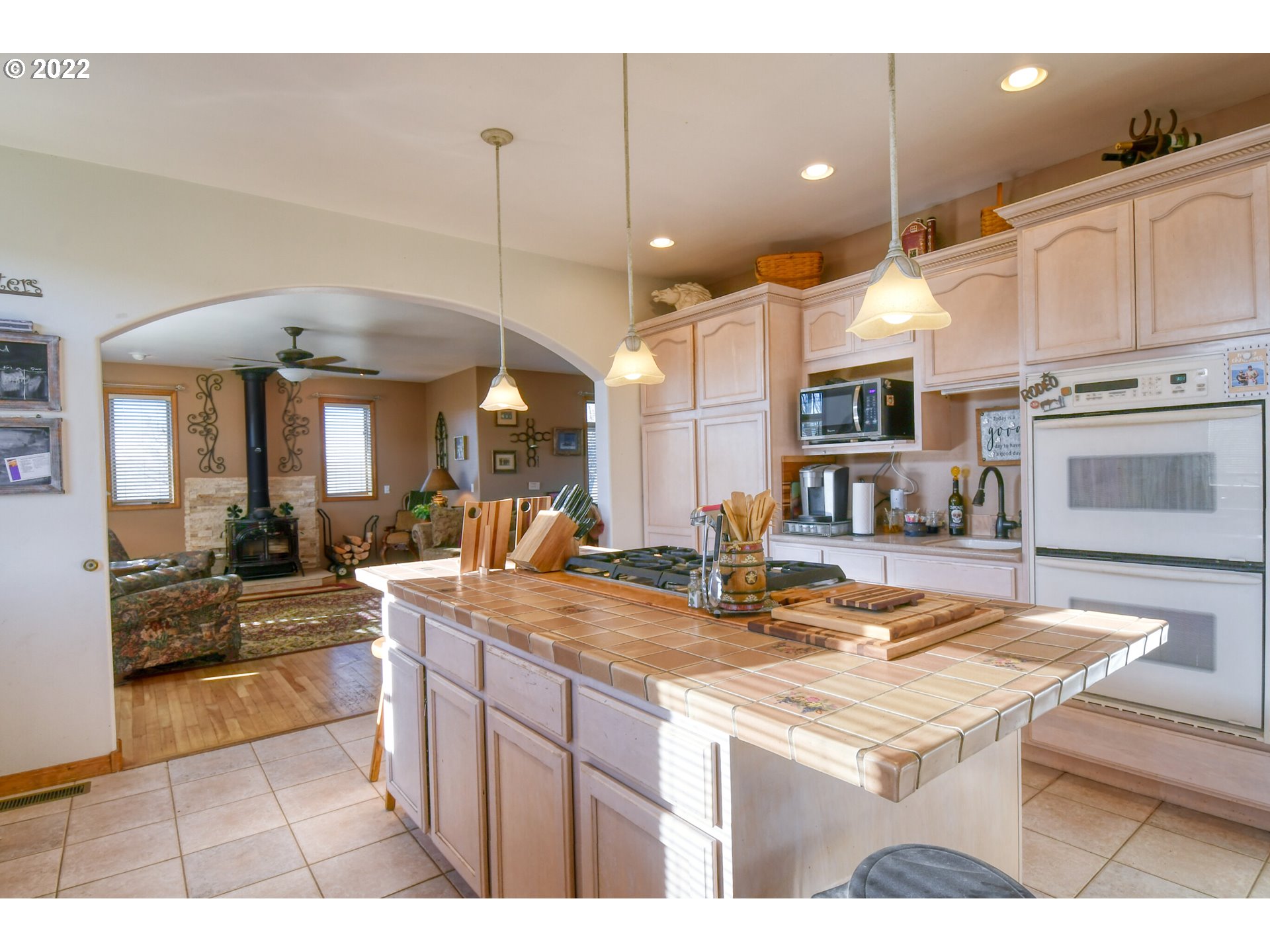 48903 Cayuse Road Pendleton, OR 97801 - Photo 20 of 32 a kitchen with kitchen island granite countertop a stove a sink a oven and a dining table with wooden floor