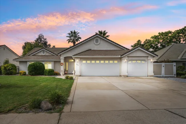 a view of a house with a big yard and large tree