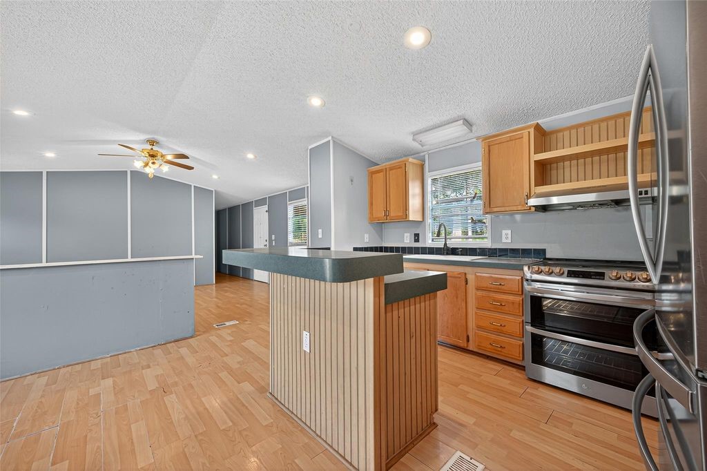 451 Trails End Drive Cleveland, TX 77328 - Photo 12 of 28 a kitchen with stainless steel appliances granite countertop a stove a sink and a refrigerator