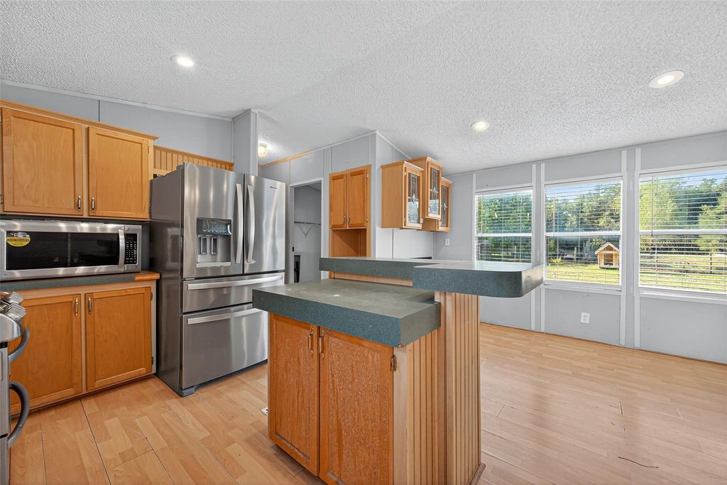 451 Trails End Drive Cleveland, TX 77328 - Photo 14 of 28 a kitchen with stainless steel appliances granite countertop a refrigerator a sink dishwasher a stove with wooden cabinets and floors