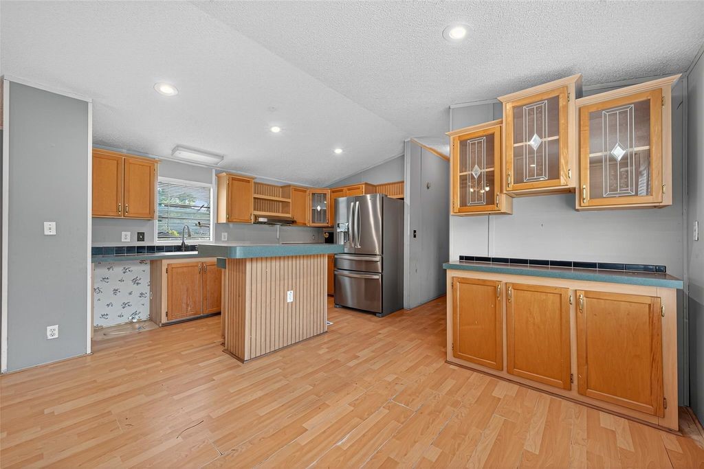 451 Trails End Drive Cleveland, TX 77328 - Photo 15 of 28 a kitchen with stainless steel appliances granite countertop a stove a sink and a refrigerator