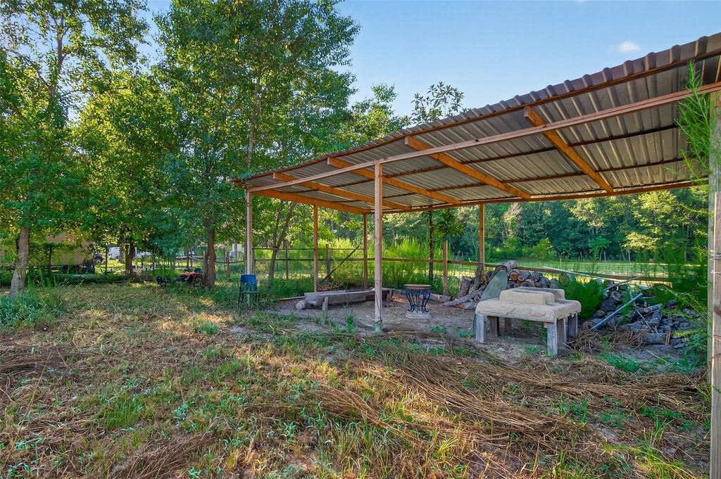 451 Trails End Drive Cleveland, TX 77328 - Photo 5 of 28 a view of a backyard with table and chairs under an umbrella