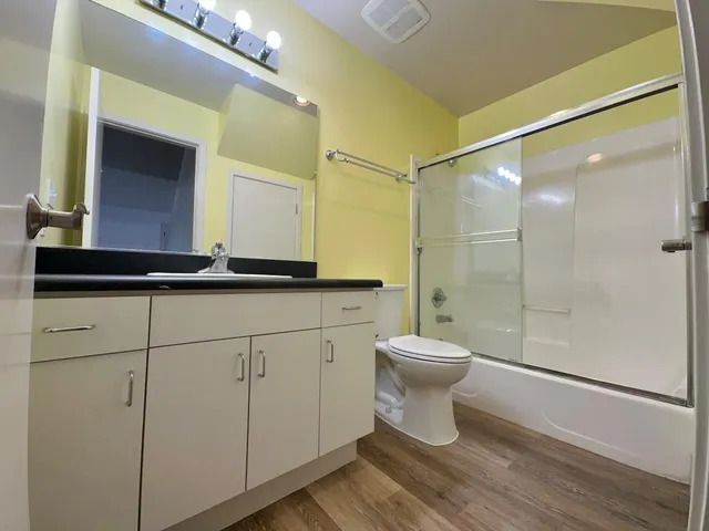 a bathroom with a sink a toilet and shower