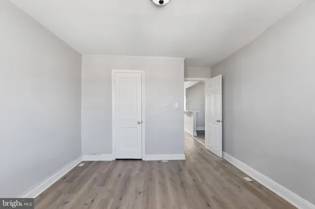 a view of an empty room with window and a ceiling fan with wooden floor