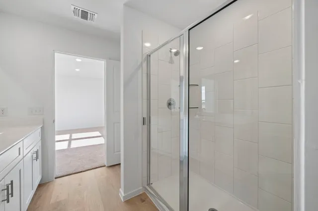 a bathroom with a shower and a glass door