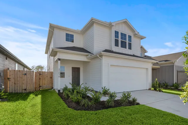 a view of a house with brick walls and a yard with plants