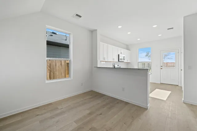 a kitchen with cabinets and wooden floors
