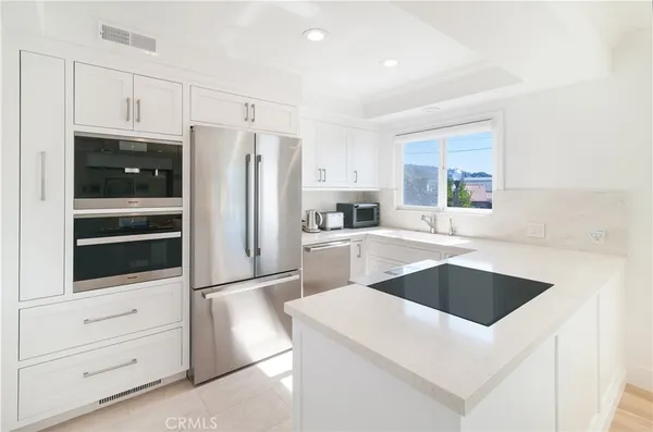 a kitchen with a refrigerator sink and cabinets