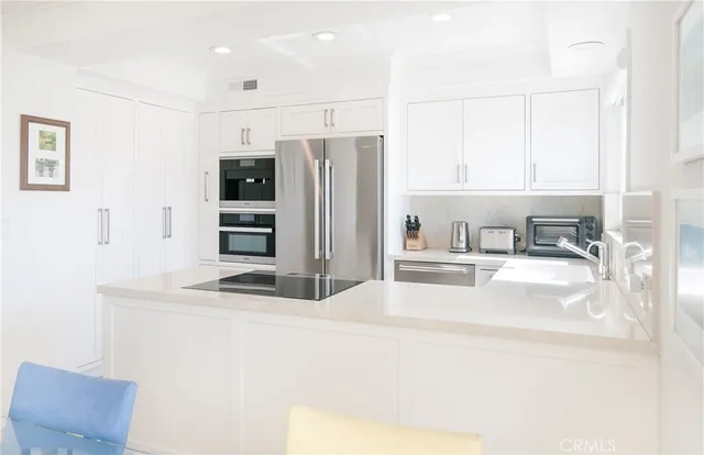 a kitchen with stainless steel appliances granite countertop a sink refrigerator and microwave