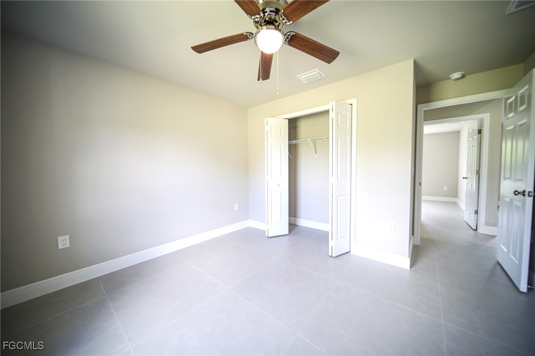 1018 Genoa Avenue South Lehigh Acres, FL 33974 - Photo 13 of 22 an empty room with closet and a chandelier fan