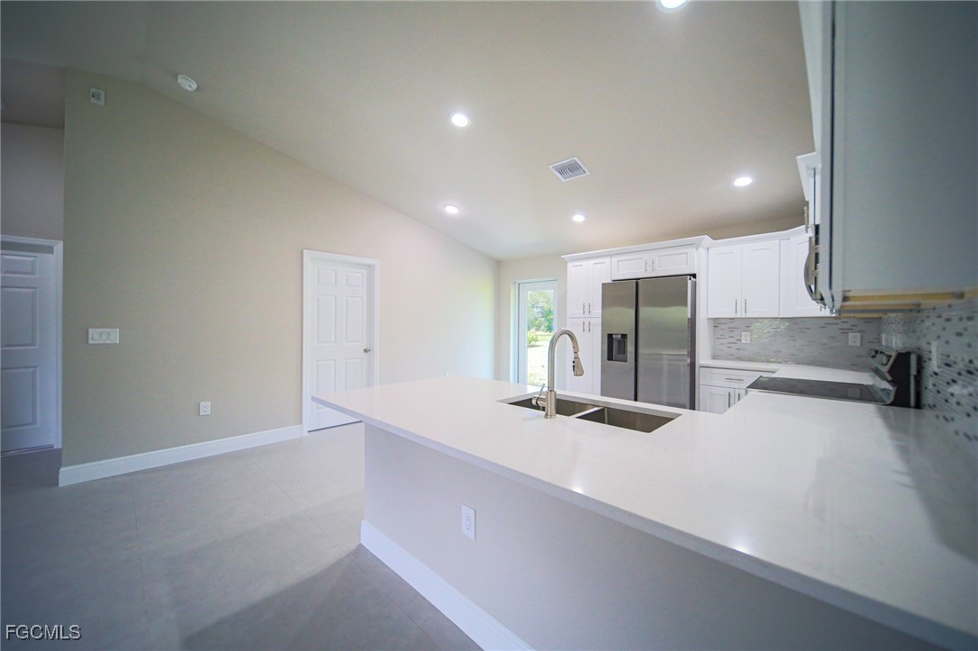 1018 Genoa Avenue South Lehigh Acres, FL 33974 - Photo 5 of 22 a kitchen with stainless steel appliances a sink and a stove top oven
