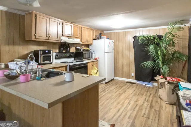 a kitchen with stainless steel appliances granite countertop a refrigerator sink and wooden cabinets