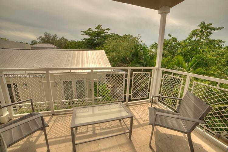 3540 Main Highway, Unit 305 Miami, FL 33133 - Photo 6 of 14 a view of a balcony with chairs and wooden floor