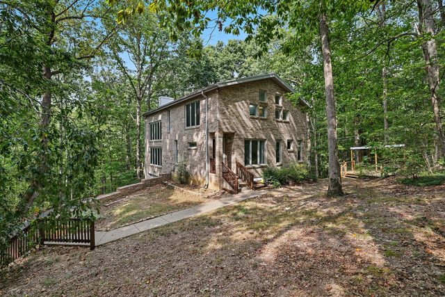 a view of a house with a yard and tree