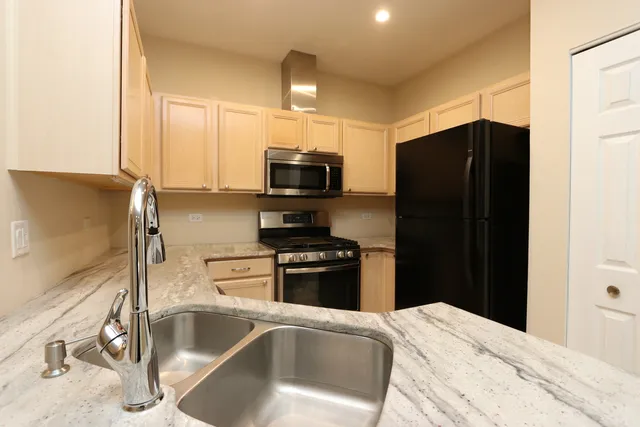 a kitchen with stainless steel appliances granite countertop a refrigerator and a sink