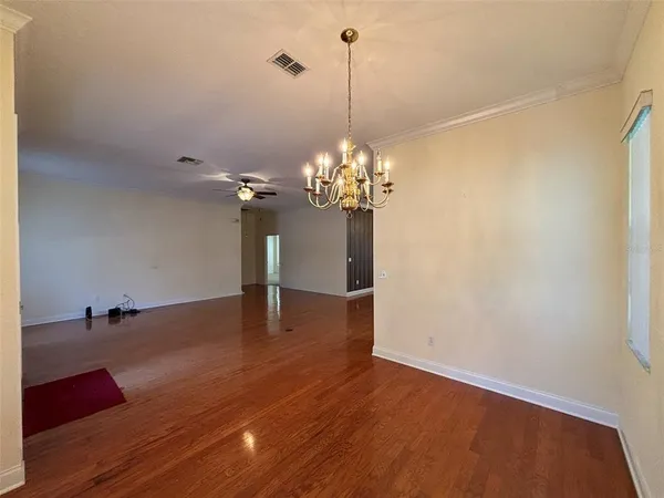 a view of a room with wooden floor and chandelier